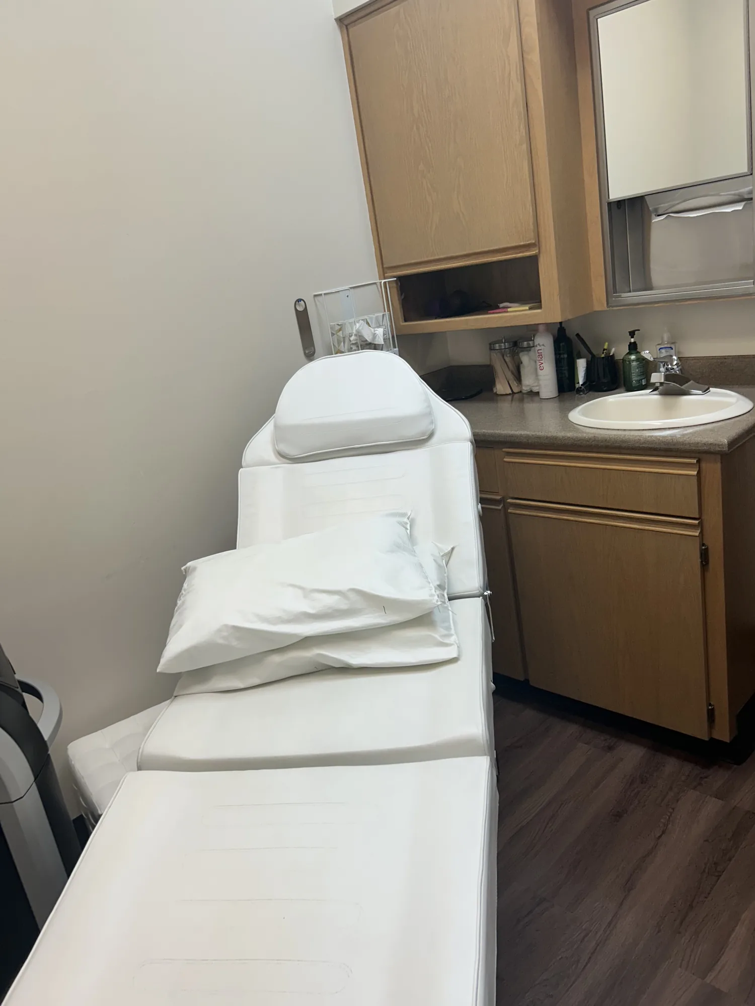 A treatment couch and sink in a private clinic room